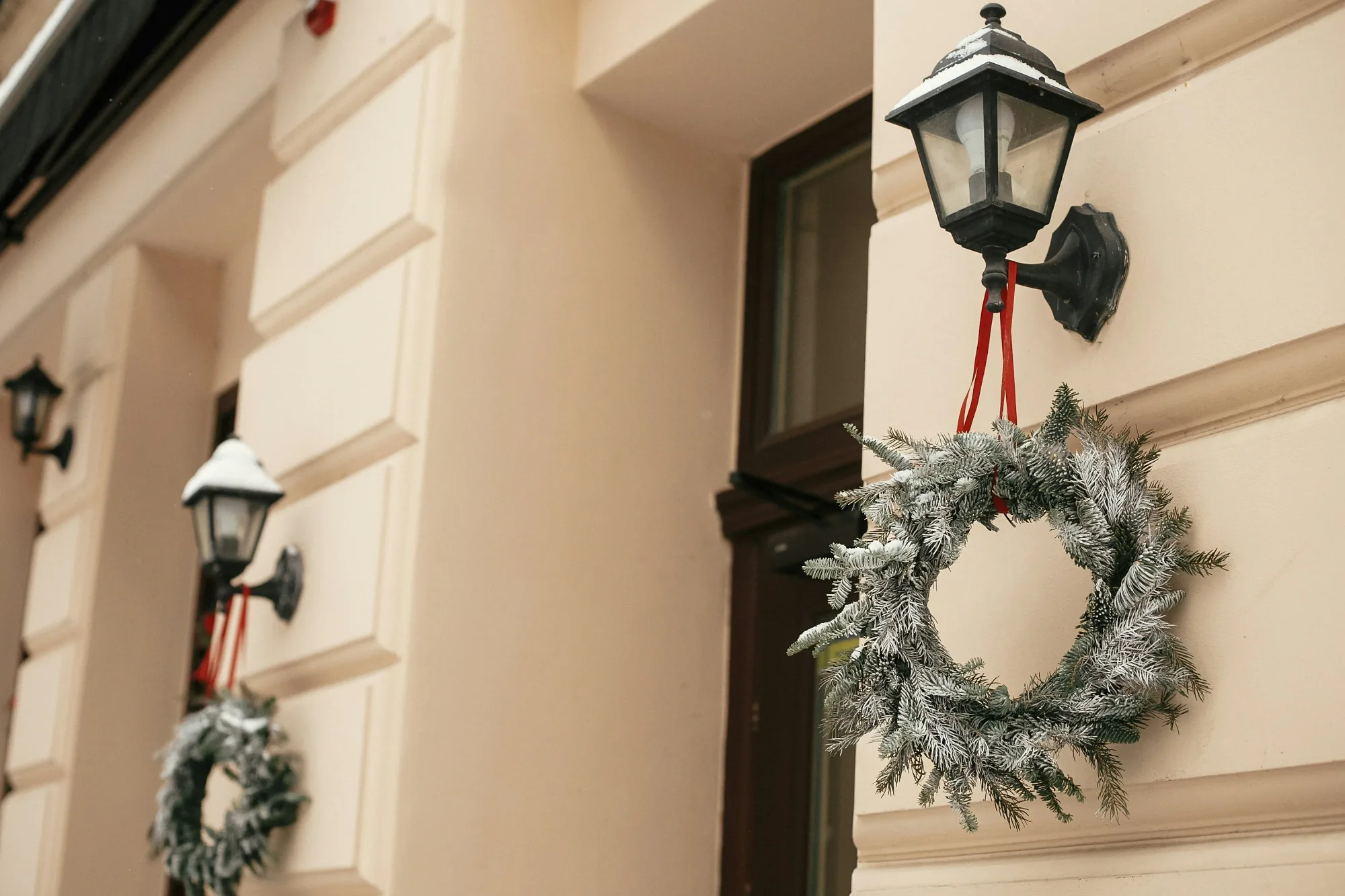Holiday wreath and evergreen against a wintry storefront