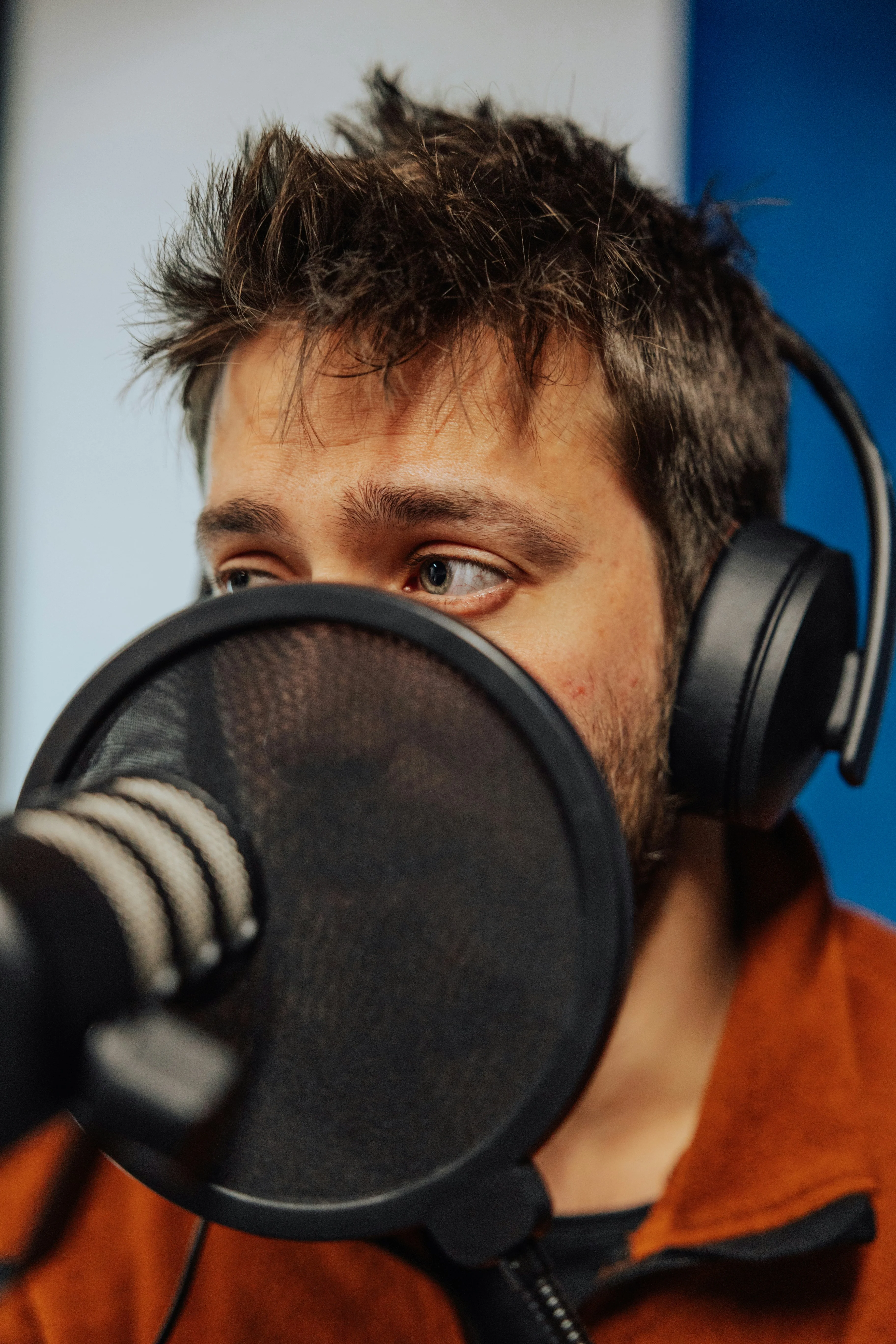 Host recording a podcast behind a studio microphone